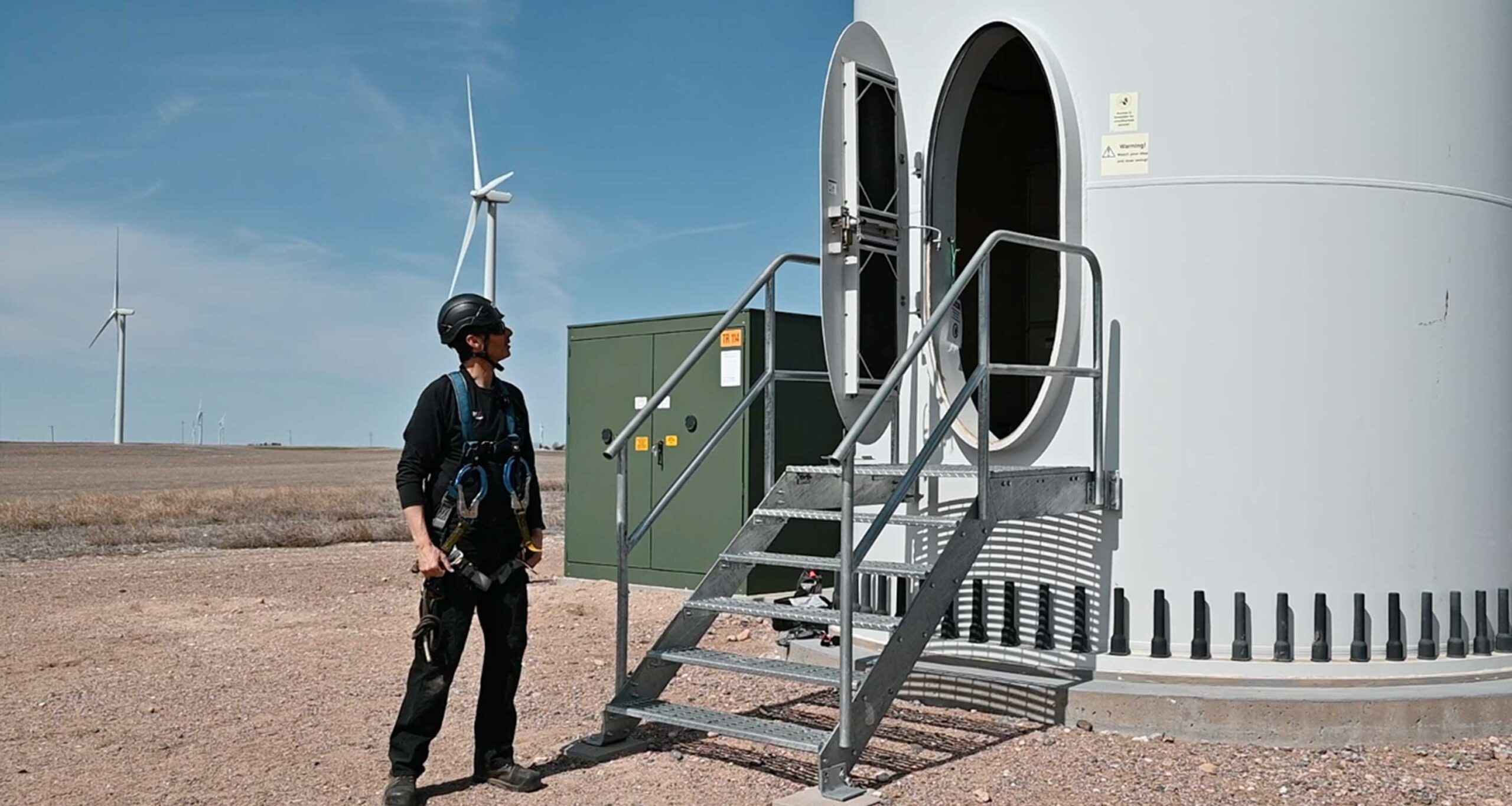 Engineer looking at onshore wind turbine wide