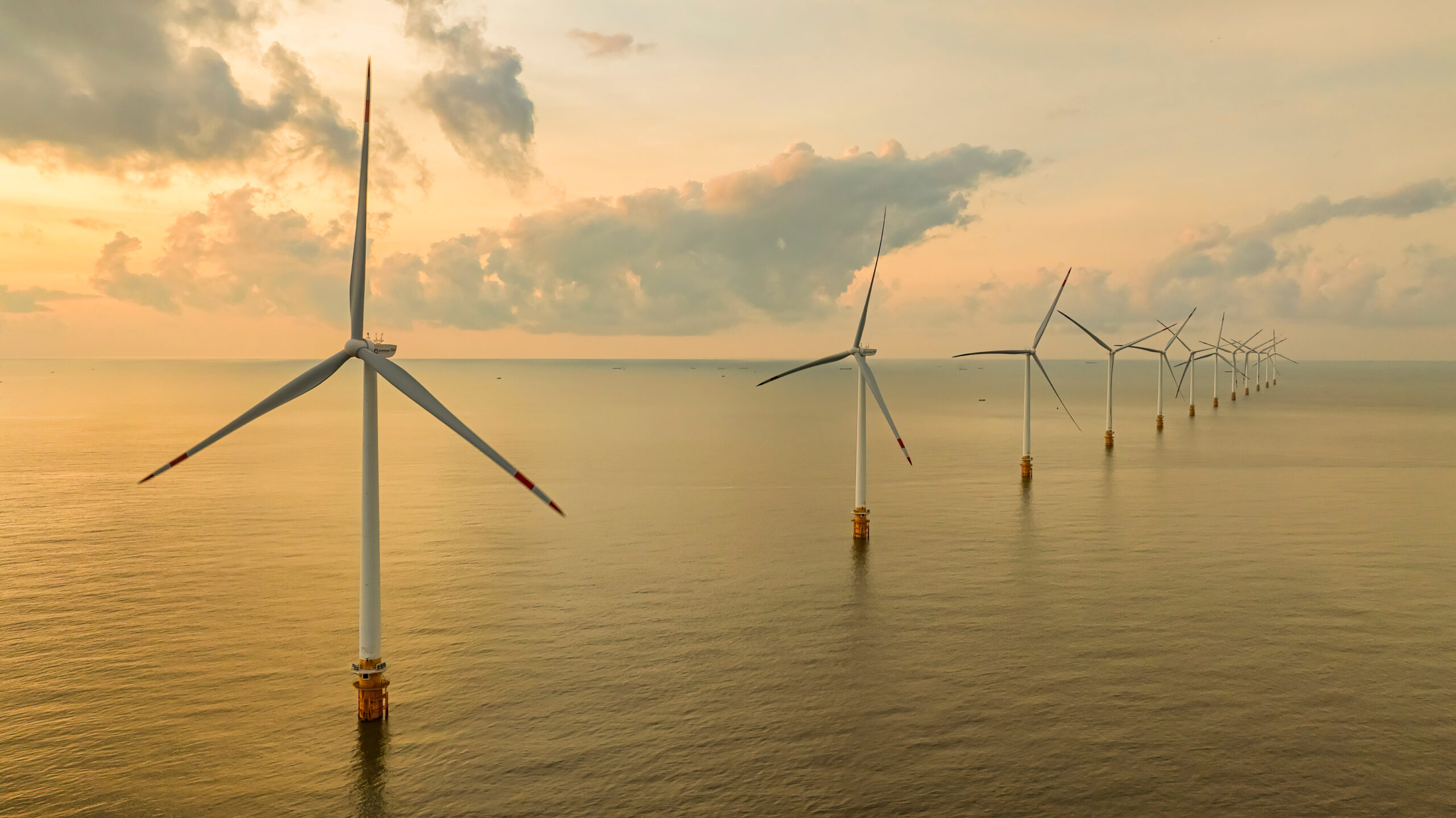 Windmill park with clouds and a blue sky, wind mill turbines in the ocean aerial view of a wind farm in the Ba Dong beach, Tra Vinh, Vietnam production clean energy